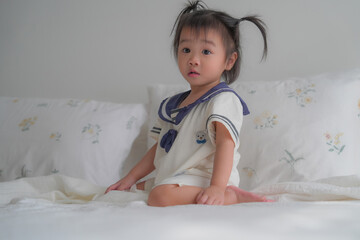 Cute baby lying on bed in soft natural light