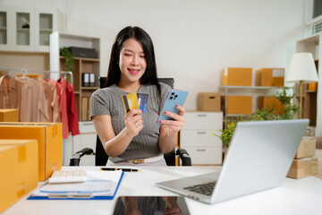 Female businessman use credit cards to conduct financial transactions through phones, tablet, and laptop.