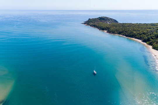 Aerial view of a cruising sailboat yacht anchored in shallow estuary, Seventeen Seventy, QLD