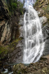 Tall Mirveti Waterfall near Gvara, Georgia, cascading over rocky cliffs surrounded by lush forest. A scenic natural attraction in the Caucasus Mountains.