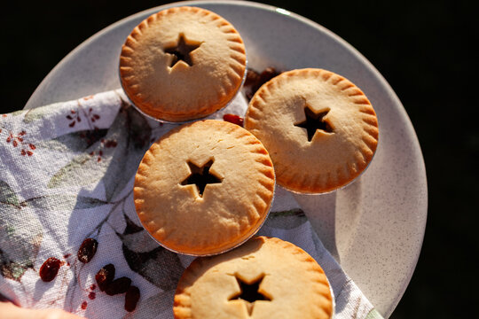 Four fruit mince pies on plate for backyard Christmas party treat