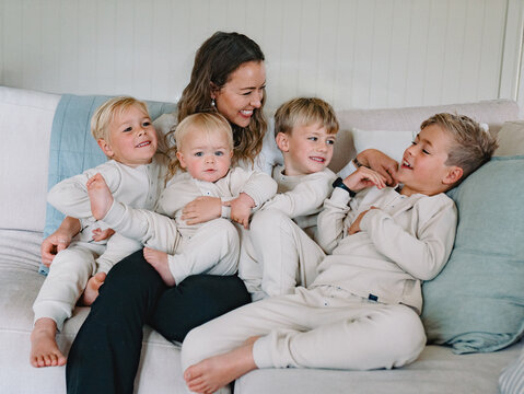 Young boys snuggling with mum on the couch