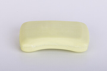 Light yellow soap bar with smooth surface and soft rounded shape isolated on white background
