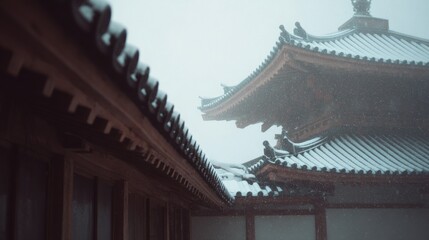 Obraz premium Close-up of a traditional japanese building with a black roof. the roof is covered in snow, and the sky is visible in the background.