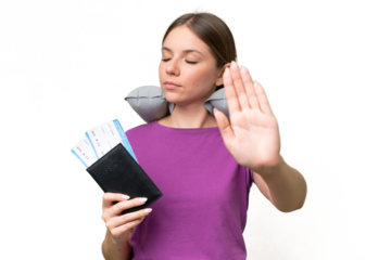 Young beautiful blonde woman with Inflatable travel Pillow over isolated background making stop gesture and disappointed