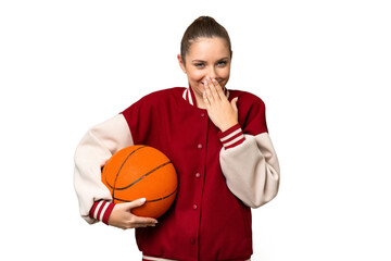 Young blonde woman playing basketball over isolated chroma key background happy and smiling covering mouth with hand