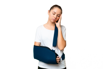 Young blonde woman with broken arm and wearing a sling over isolated chroma key background with headache