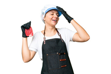 Butcher woman wearing an apron and serving fresh cut meat over isolated chroma key background smiling a lot