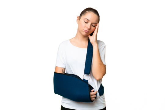 Young blonde woman with broken arm and wearing a sling over isolated chroma key background with headache