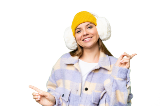 Young blonde woman wearing winter muffs over isolated chroma key background pointing finger to the laterals and happy