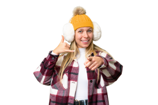 Young pretty blonde woman wearing winter muffs over isolated chroma key background making phone gesture and pointing front