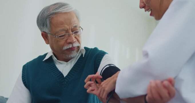 Young Asia female doctor with old man patient using blood pressure consultation or cardiology wellness or hypertension, checkup or healthcare on sofa in health clinic office. Medical worker for care. - Powered by Adobe