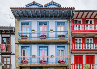 Traditional House Facade, Colorful Blue Balconies, and Red Shutters in the Basque Region of Spain