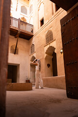 Woman traveling in oman exploring traditional courtyard architecture