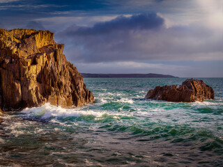 Powerful ocean waves crashing against the rocky coastline.