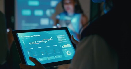 Close up group Asian businesspeople work together leads business meeting uses presentation TV with profit sale statistics in office night. Financial generation z team brainstorm on e-Commerce project. - Powered by Adobe