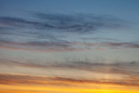 skyscape and cloudscape of blue and grey streaked sky with white and golden yellow sunset with space for copy and titles Scotland UK