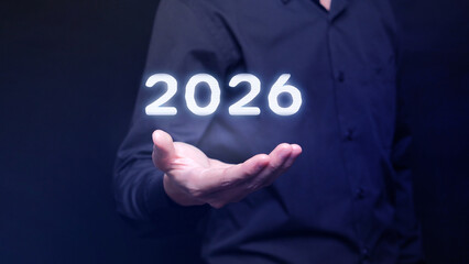 Businessman Hand Holding Glowing Digital 2026, Symbolizing Future Investment, New Year Opportunity, and Business Vision Concept.