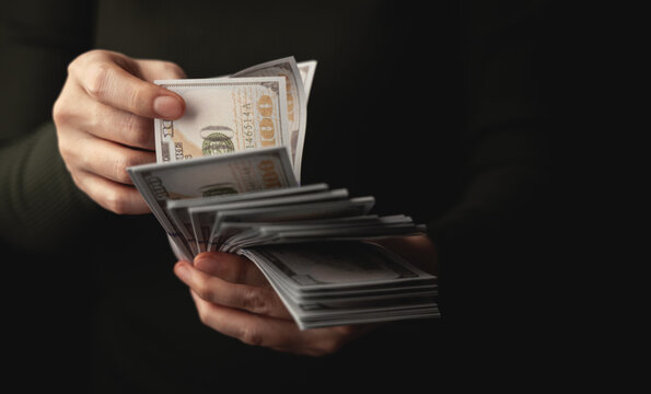 Hands counting US dollar banknote, symbolizing finance, payment, banking