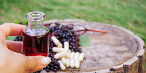 Elderberry berries, syrup, and herbal supplement capsules for natural cold and flu remedy.