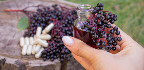 Elderberry berries, syrup, and herbal supplement capsules for natural cold and flu remedy.
