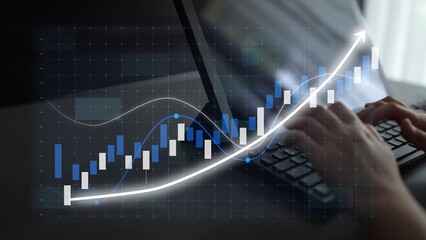 A close-up of hands typing on a laptop keyboard, displaying a digital chart that illustrates the rise of stock market trends in a modern workspace setting. Copula