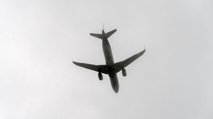 A commercial jet is flying through the cloudy skies. It is a scheduled passenger flight of an airline. High quality photo