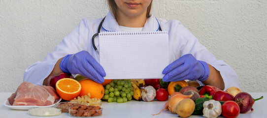 Nutritionist holding a blank notepad for writing a diet plan among fruits and vegetables