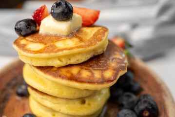 Close-Up Stack of Pancakes on Plate with Butter and Berries