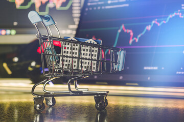 Real estate investment concept with shopping cart and stock market chart