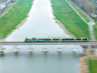 pociąg osobowy jedzie szybko przez most nad rzeką © Henryk Niestrój