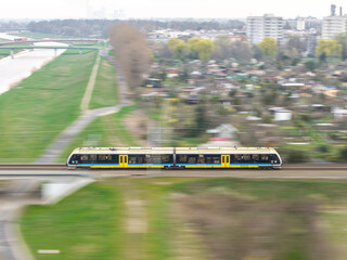 pociąg osobowy jedzie szybko przez most nad rzeką © Henryk Niestrój