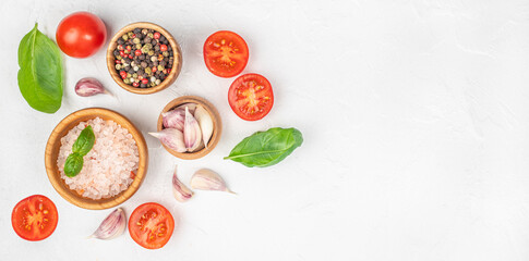 Fresh cooking ingredients with tomatoes, garlic, basil and spices on white textured background with copy space