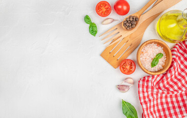 Fresh cooking ingredients and kitchen utensils on a white textured background with copy space