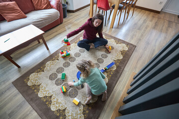 Mother and child playing with blocks on living room floor
