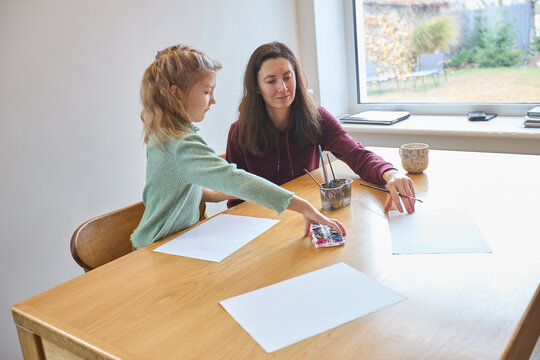 Mother and daughter engaging in creative indoor art activities together