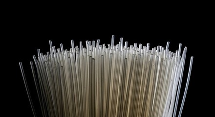 Dramatic low-angle macro view of a dense bundle of semi-transparent polymer rods, creating an abstract technological texture against a solid black background