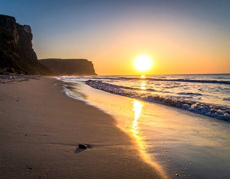 Beach shoreline with rocky cliffs under a brilliant sunrise