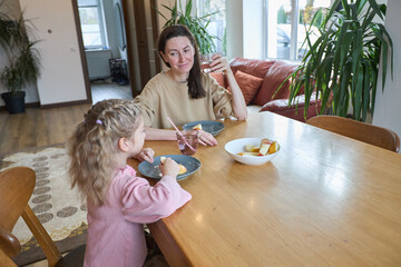 Mother and daughter enjoying breakfast together at home