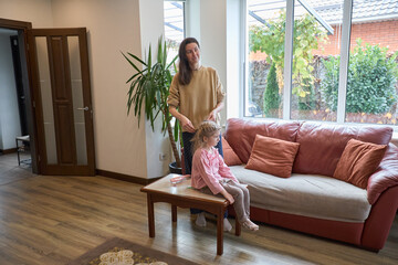Obraz premium Mother and daughter in cozy living room with modern decor and natural light