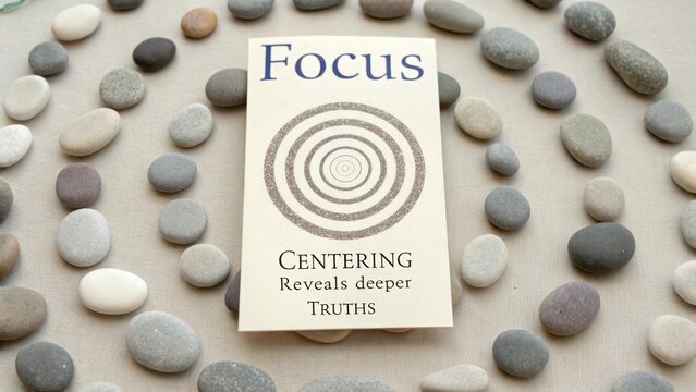 Book about focusing and centering surrounded by smooth polished stones for mindfulness and meditation