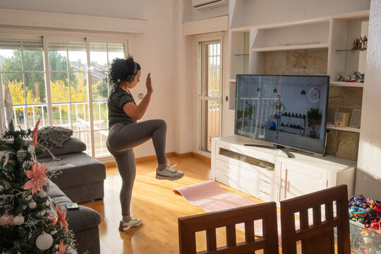 Woman exercising home workout online class in living room