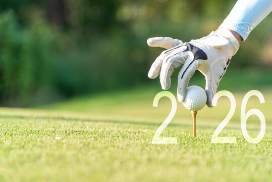 Close up hand Golfer woman putting golf ball for Happy New Year 2026 on the green golf for new healthy.  copy space. Healthy and Holiday Concept