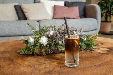Espresso tonic cocktail with lemon on wooden table

