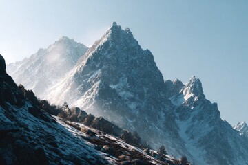 Majestic Snow-Capped Mountain Peaks Under Clear Blue Sky with Gentle Clouds
