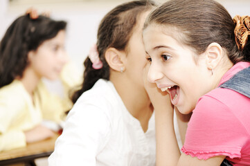 Obraz premium Happy children with their teacher in classroom, doing