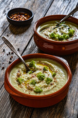 Cream of broccoli soup on wooden table	
