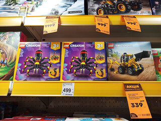 Fototapeta premium Zvyagel, Ukraine - November 20, 2025: LEGO Creator 3-in-1 spider and Technic construction vehicle sets displayed on store shelf, showcasing colorful packaging and engaging design for children