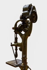 A cutout of an antique green vertical pillar drilling machine (drill press) with a belt-driven...