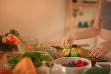 cropped shot woman preparing fresh broccoli and vegetables in her kitchen